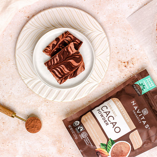 A bag of Navitas Organics Cacao Powder and a plate of treats made with it.