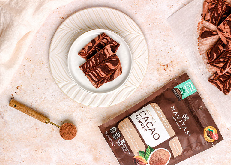 A bag of Navitas Organics Cacao Powder and a plate of treats made with it.