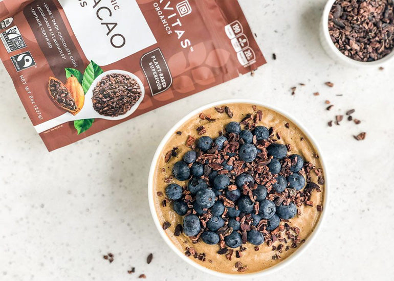 Navitas Organics Fairtrade certified Cacao Nibs on top of a smoothie made with Navitas Organics Fairtrade certified Cacao Powder.