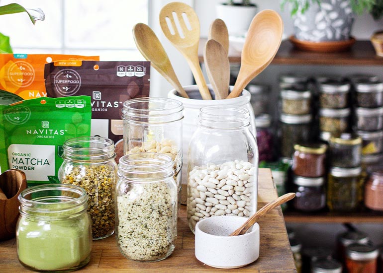 Jarred foods and seeds sitting on shelves in a kitchen