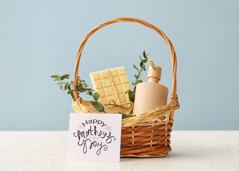 A mother's day greeting card resting against a basket filled with various gifts