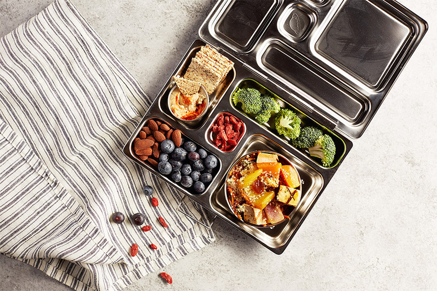 A lunchbox filled with healthy fruits, snacks, and Navitas Organics superfoods.
