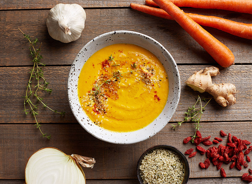 A bowl of hearty soup made with Navitas Organics Turmeric Powder, topped with Navitas Organics Hemp Seeds.
