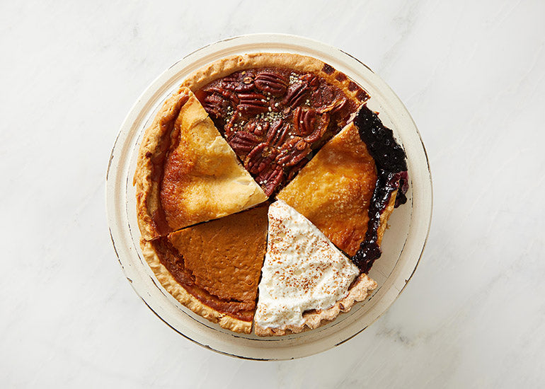 A round pie dish filled with slices of different types of pie made with Navitas Organics superfood ingredients.