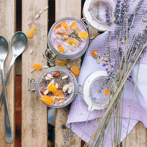 Two chia puddings made with Navitas Organics Chia Seeds with spoons and lavender on a wooden table
