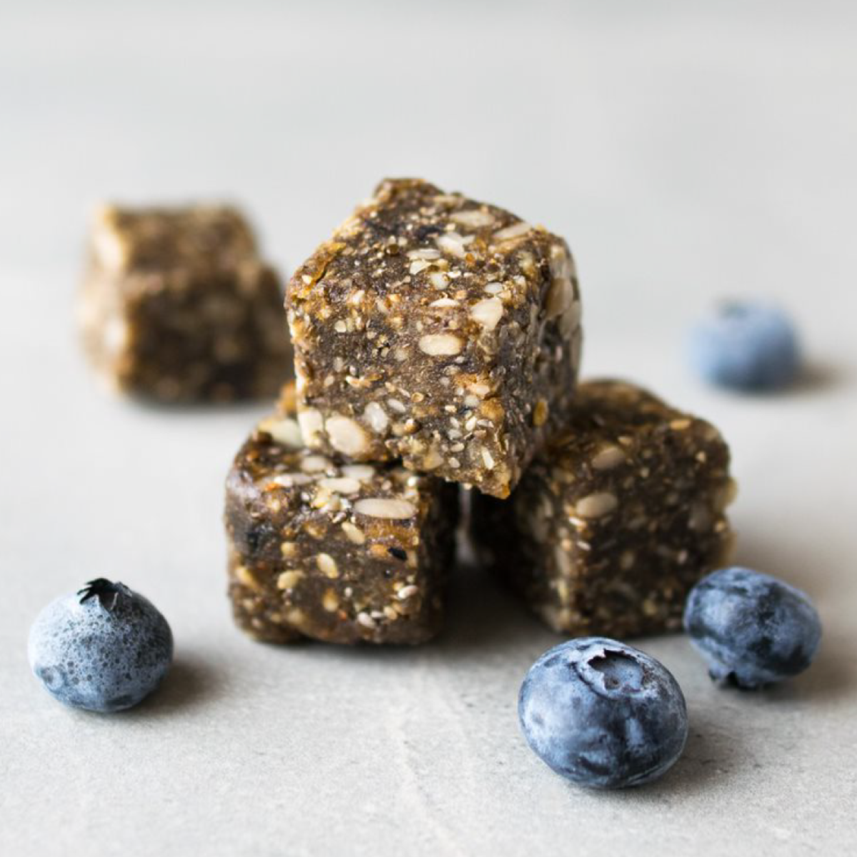Stack of Navitas Organics Power Snacks with blueberries on a light surface