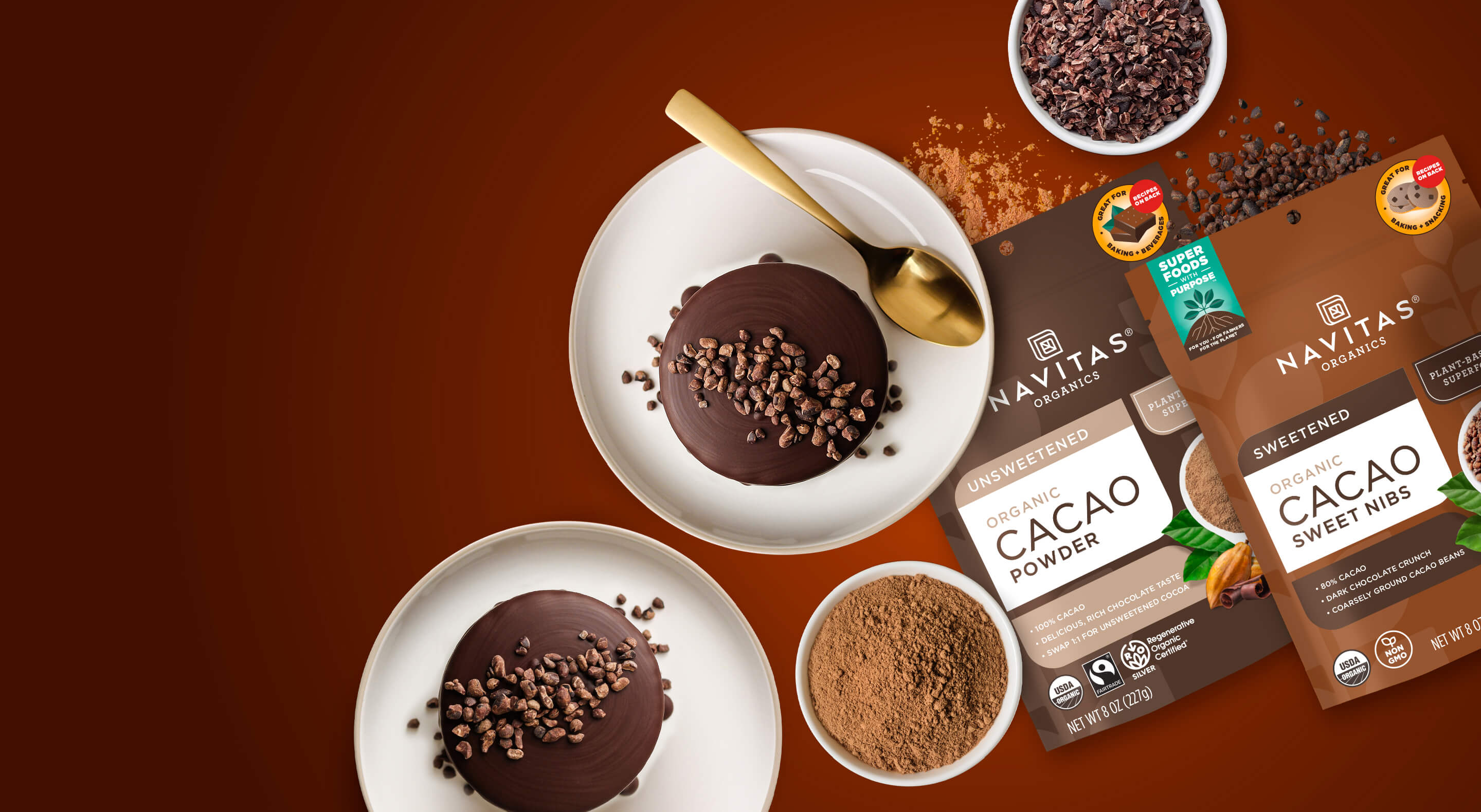 Navitas Organics Cacao Powder and Cacao Sweet Nibs packages next to mini chocolate cakes topped with cacao nibs and small dishes filled with Cacao Powder and Cacao Nibs.