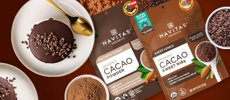 Navitas Organics Cacao Powder and Cacao Sweet Nibs packages next to mini chocolate cakes topped with cacao nibs and small dishes filled with Cacao Powder and Cacao Nibs.