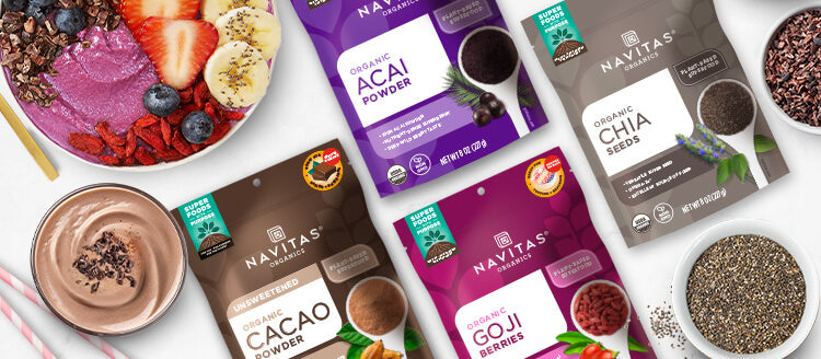 Navitas Organics products including acai powder, cacao powder, chia seeds, and goji berries on a white background.