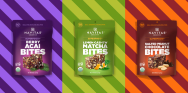A row of Navitas Organics Superfood+ BITES featuring Berry Acai, Lemon Cashew Matcha and Salted Peanut Chocolate BITES against different colored striped backgrounds.
