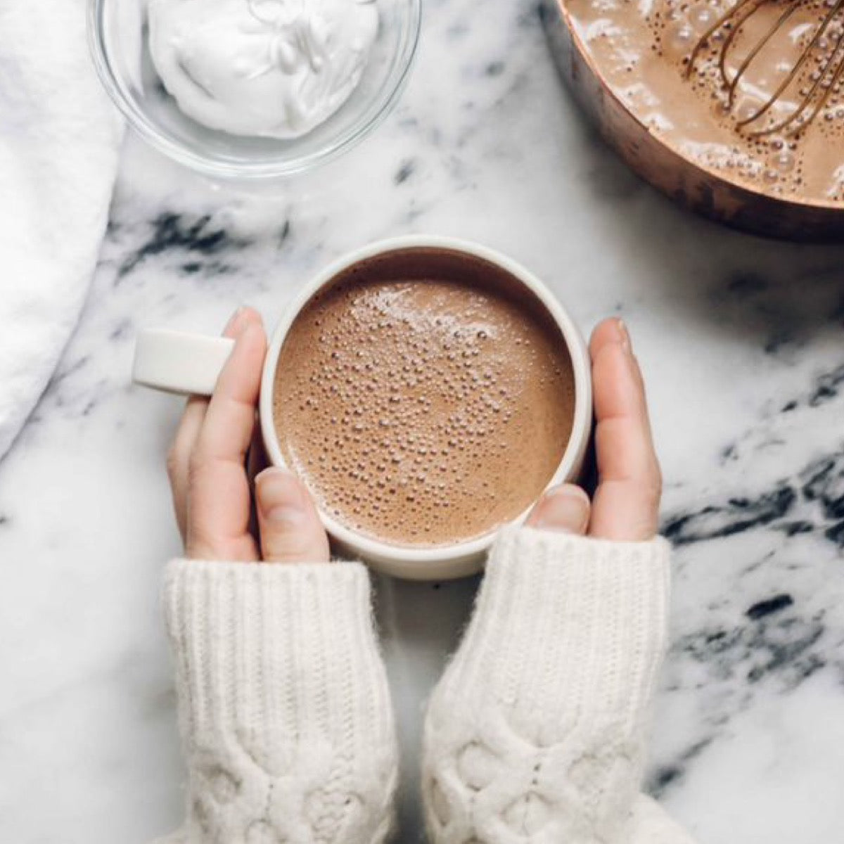 Two hands around a cup of hot cocoa made with Navitas Cacao Longevity 