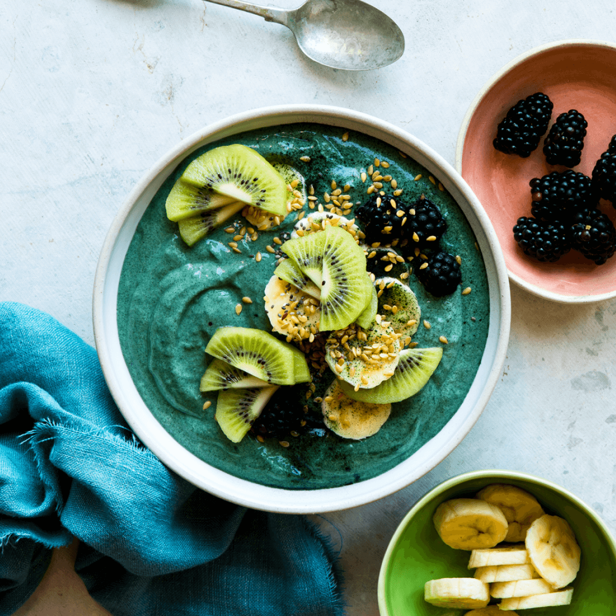 Vibrant smoothie bowl made with Navitas Essential Superfood Blend Vanilla & Greens and topped with bananas, kiwi and blackberries.